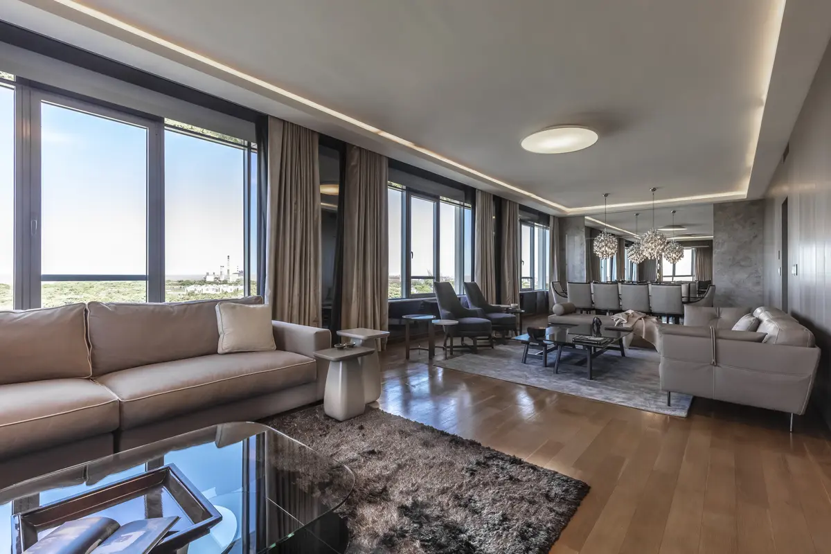 Sala de estar moderna com janelas amplas, sofá modular e jantar — projeto Departamento Edificio El Faro, por Viviana Melamed, em CABA