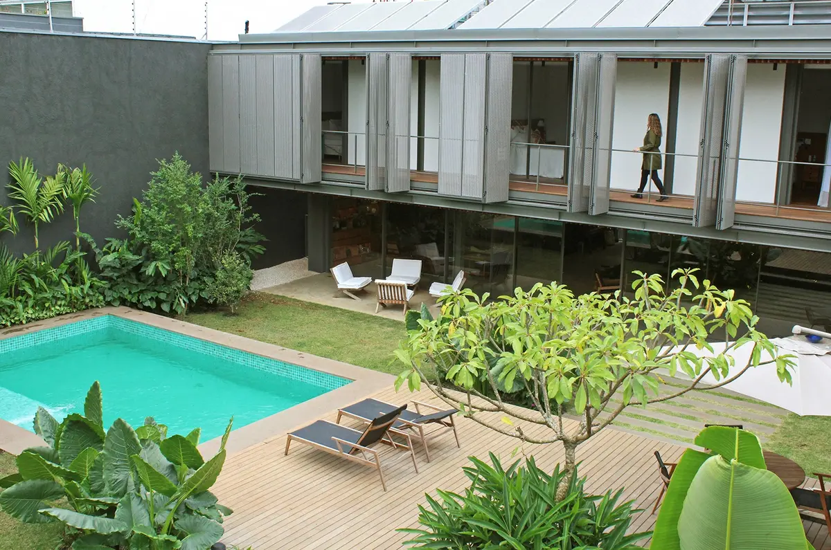 Patio moderno con pileta, deck de madera y jardín tropical — proyecto Residência MC, por Gil Fialho