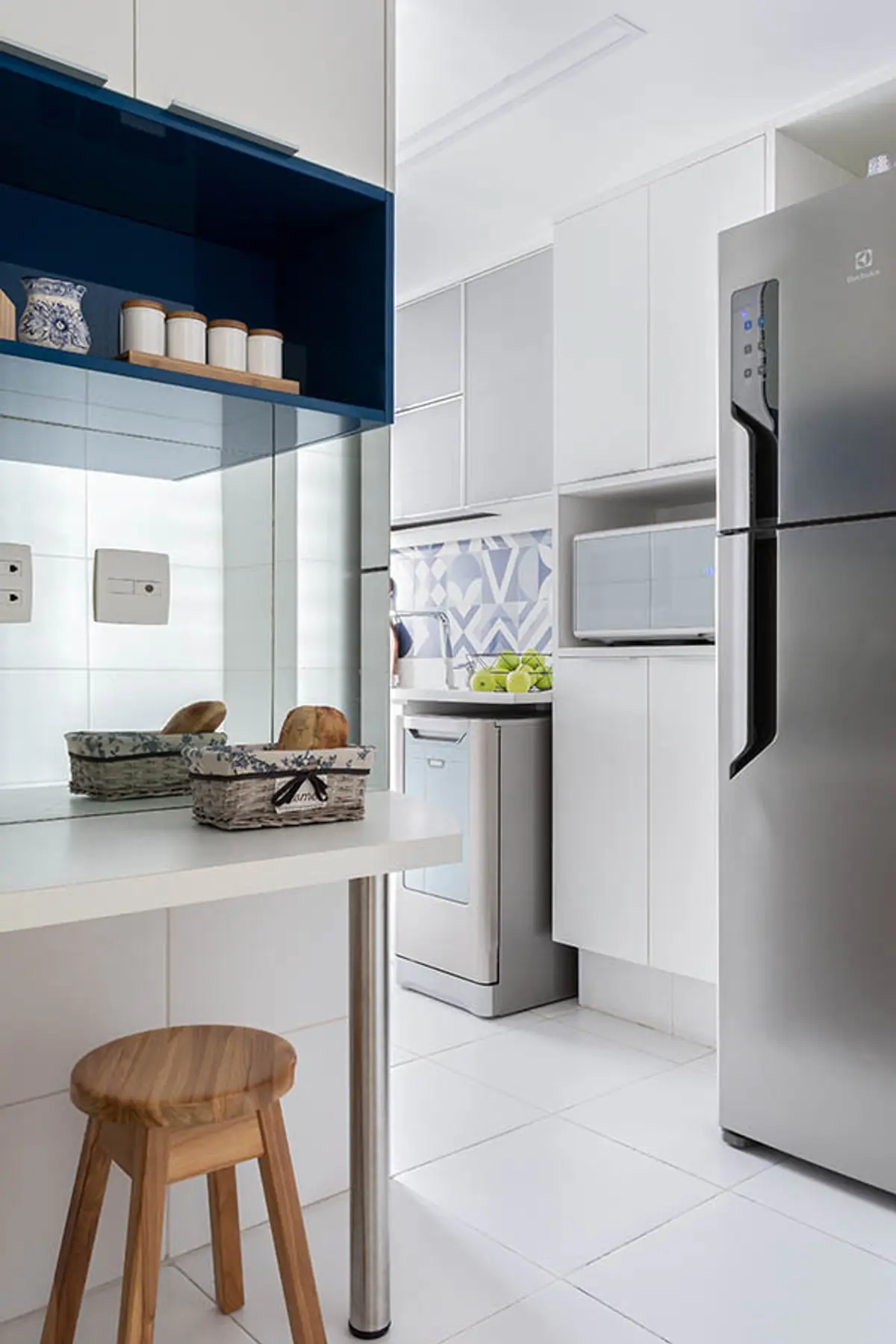 Cocina moderna blanca con isla de marmol, taburete madera y detalles azules — proyecto Apartamento Nóbrega, por Amanda Miranda