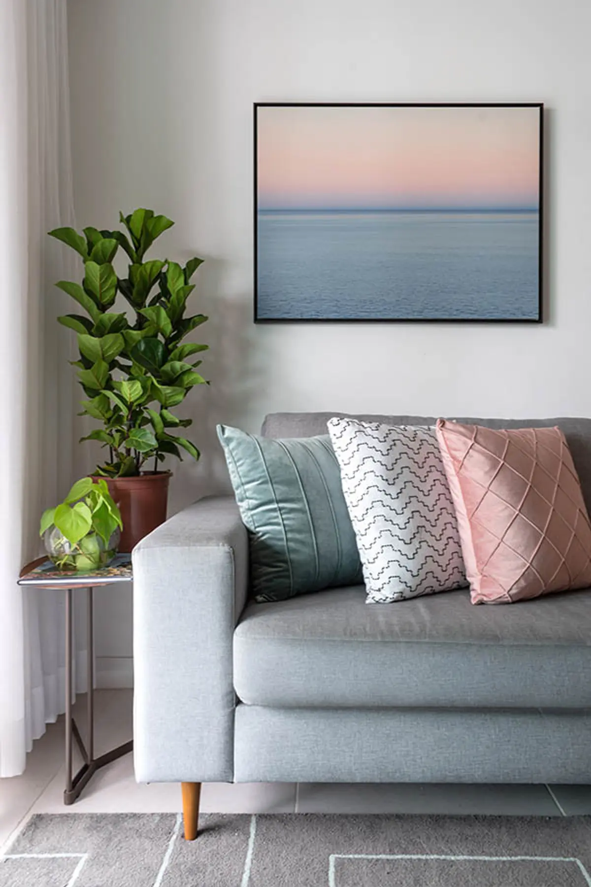 Living moderno con sofá gris, plantas y cuadro paisaje marino — proyecto Apartamento Nóbrega, por Amanda Miranda