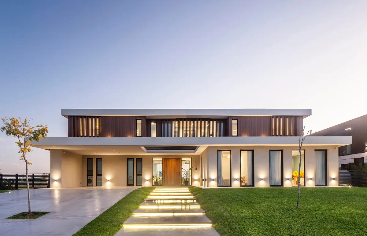 Fachada moderna de dois andares com janelas do chão ao teto e detalhes em madeira — projeto CASA C313, por A'PRIMA - Arquitectura Sustentable, em Provincia de Buenos Aires