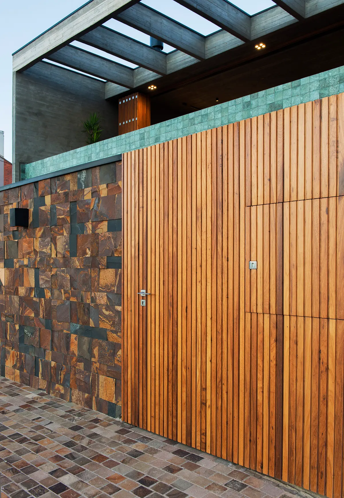 Fachada moderna com portão de madeira e muro de pedra — projeto CASA OCEANO, por Mayresse Arquitetura