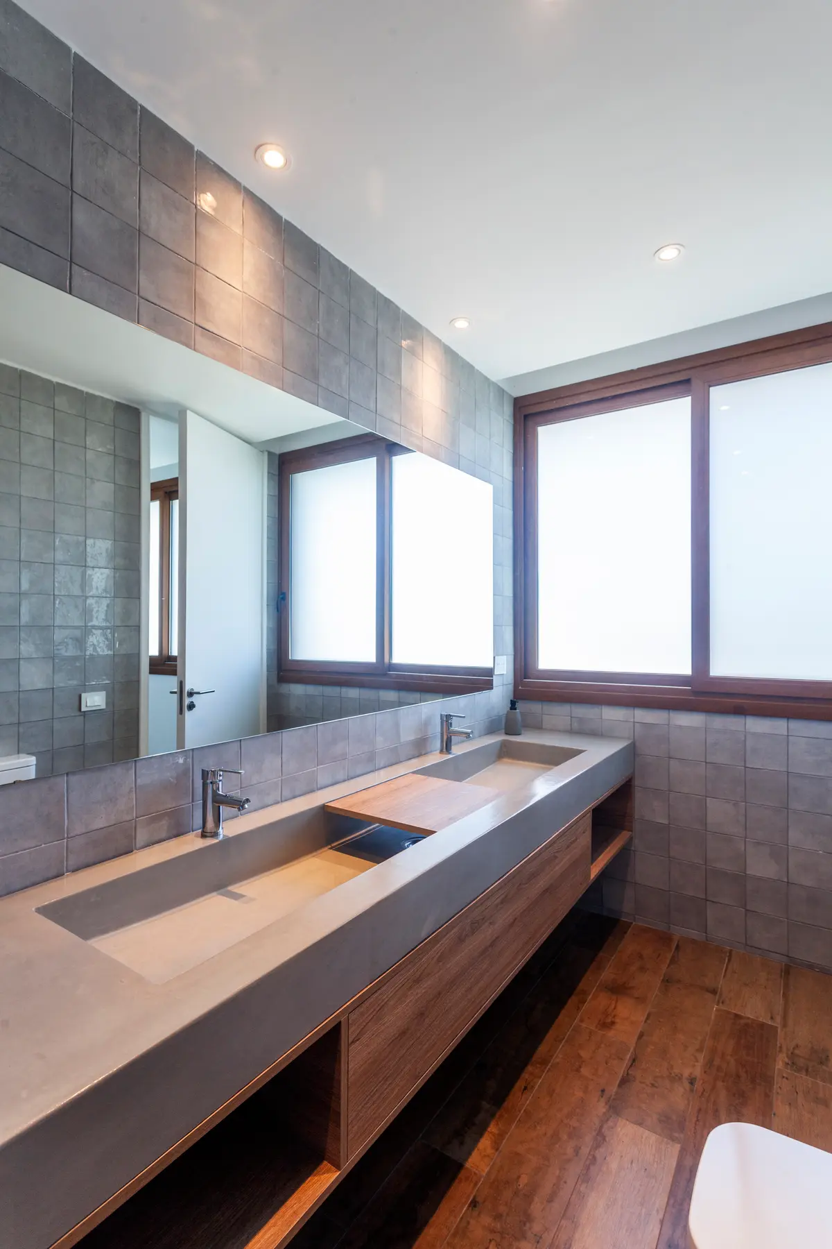 Banheiro moderno com pia dupla de cimento e azulejos cinzas — projeto Casa Green, por Frato construcciones, em Belén de Escobar