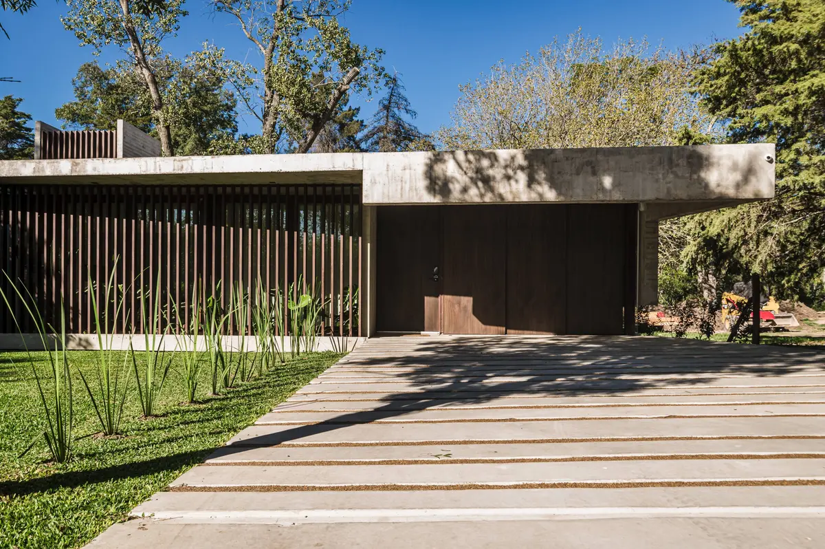 Fachada moderna com ripas de madeira verticais e concreto — projeto Casa Arq César Cassolino, por MUCHTEK, em La Plata