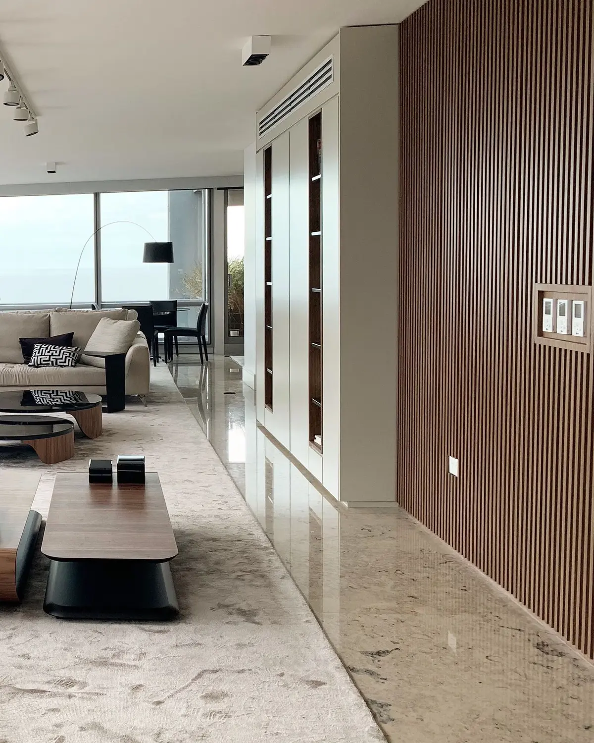 Sala de estar moderna com parede de ripas de madeira e amplas janelas — projeto Forum - Estudio Made it, por ABEJA CONCEPT, em Belgrano