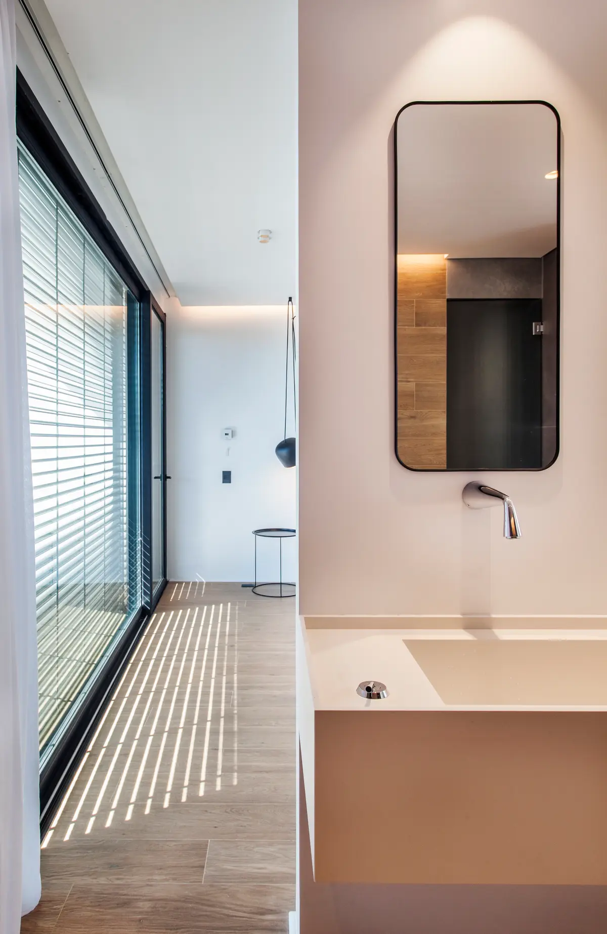 Banheiro moderno minimalista com janela e jogo de luz e sombra — projeto CASA WINDBELLS, por ABAD GADANO, em Tigre