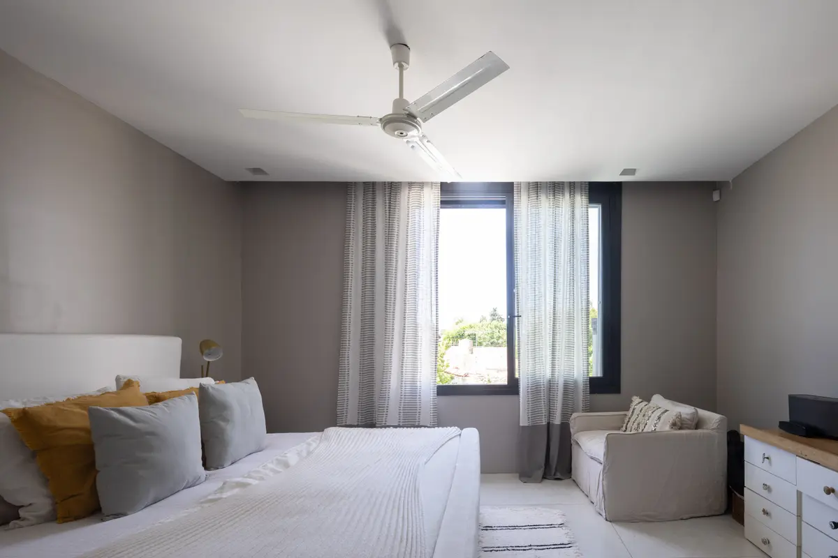 Dormitorio moderno con cama baja, sillón curvo y cortinas transparentes — proyecto CASA OrBa, por Alfredo Orfila arquitectura, en San Isidro