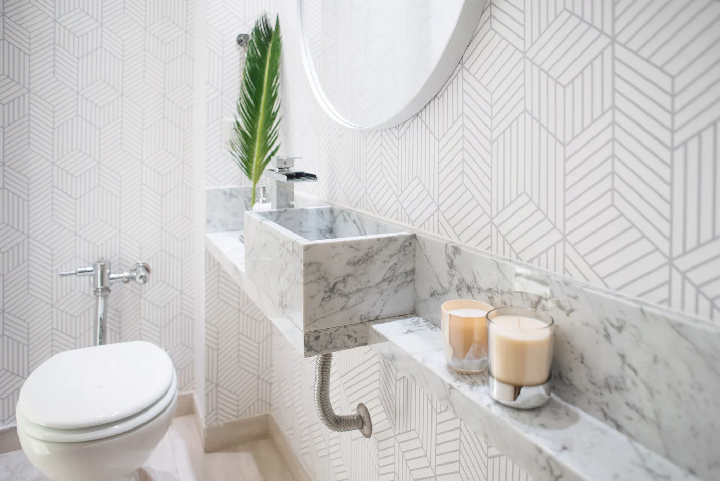 Baño moderno con papel geométrico y mármol