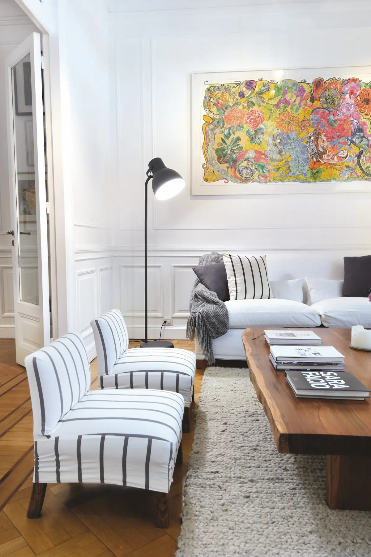 Living moderno con sillones rayados, sofá gris y obra colorida en pared — proyecto Callao, por Estudio Diez Muzzio, en CABA