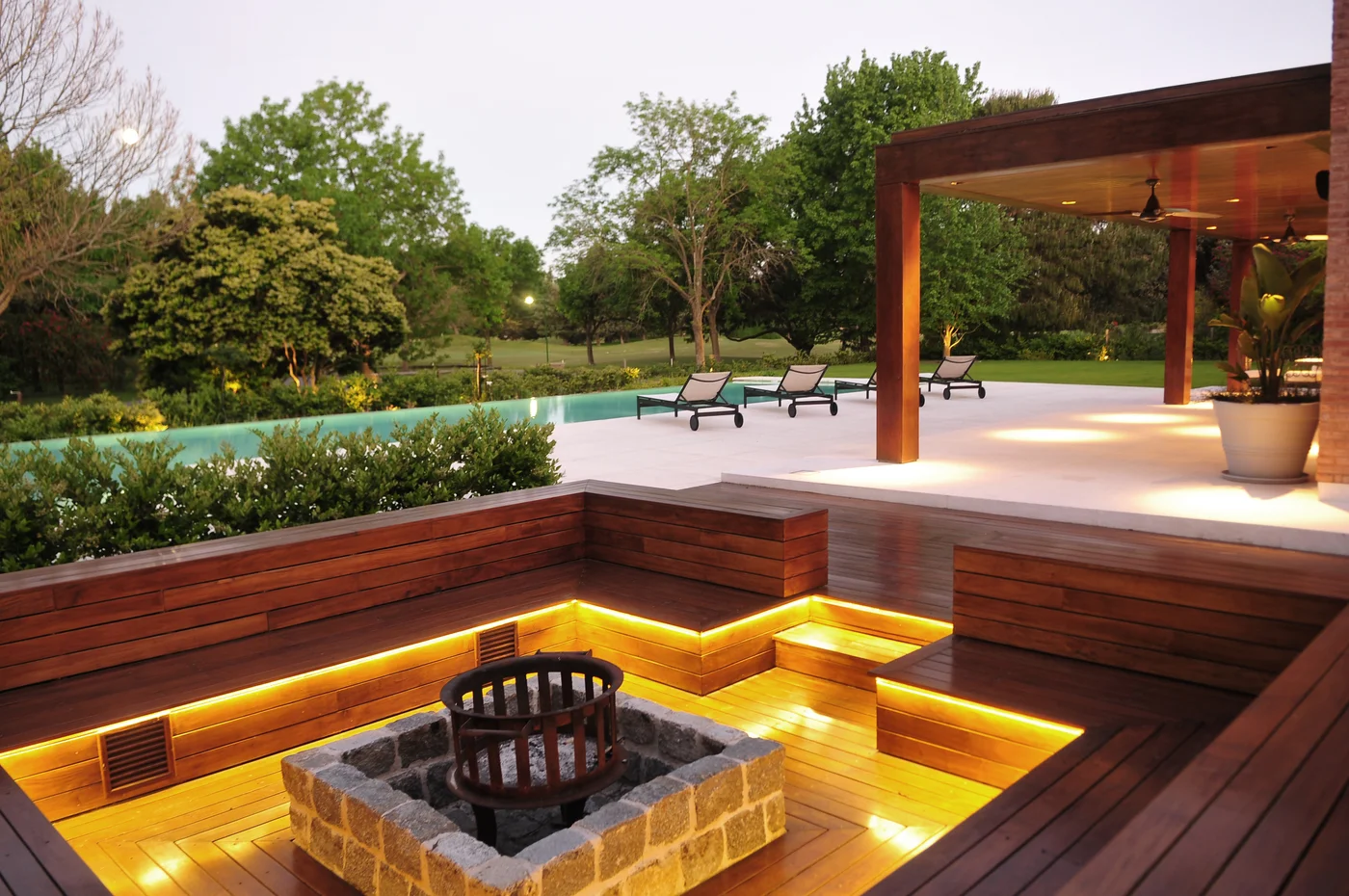 terraza moderna con pérgola, asientos integrados e iluminación cálida