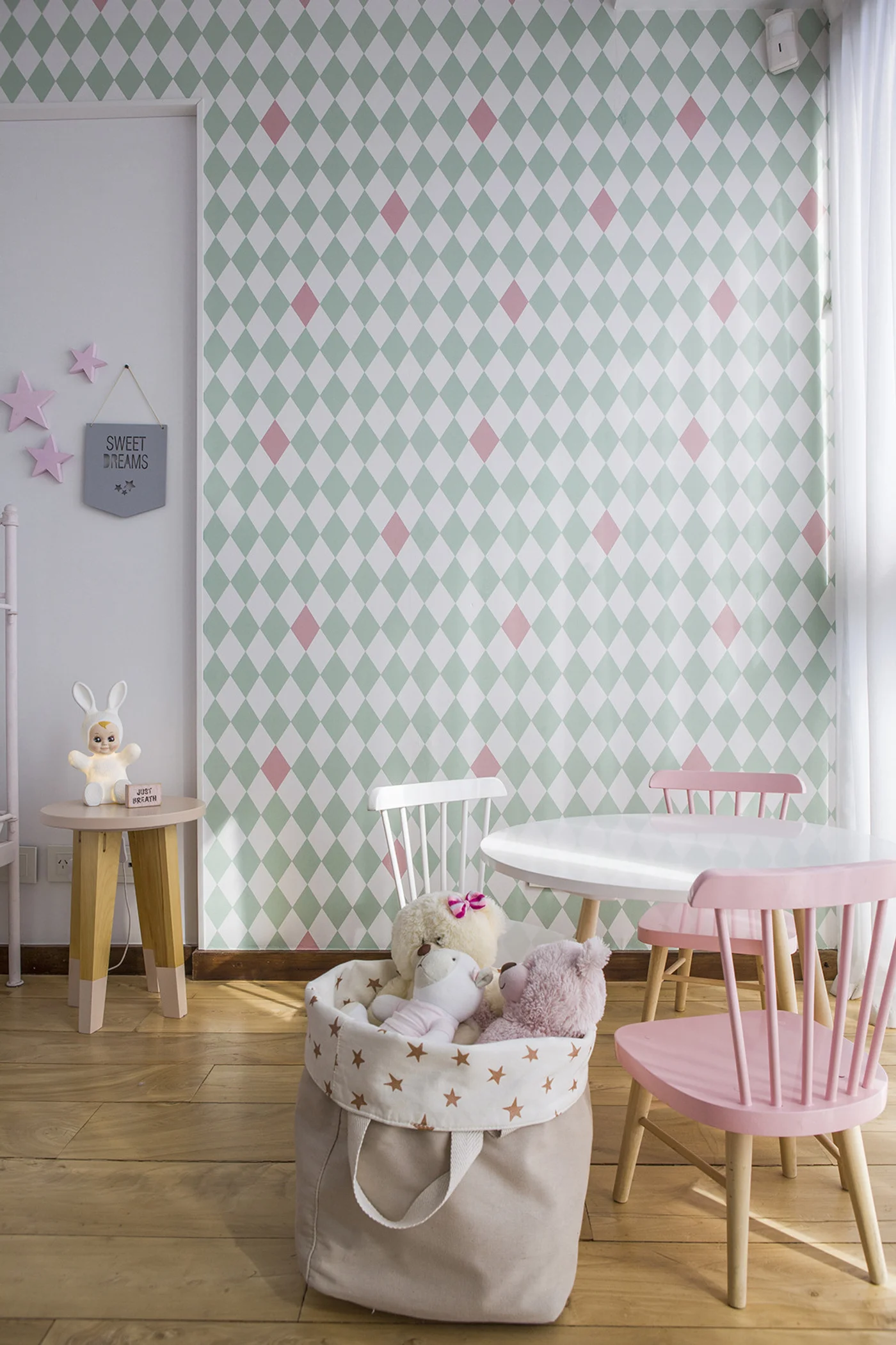 Habitación infantil con papel tapiz de rombos y muebles color pastel