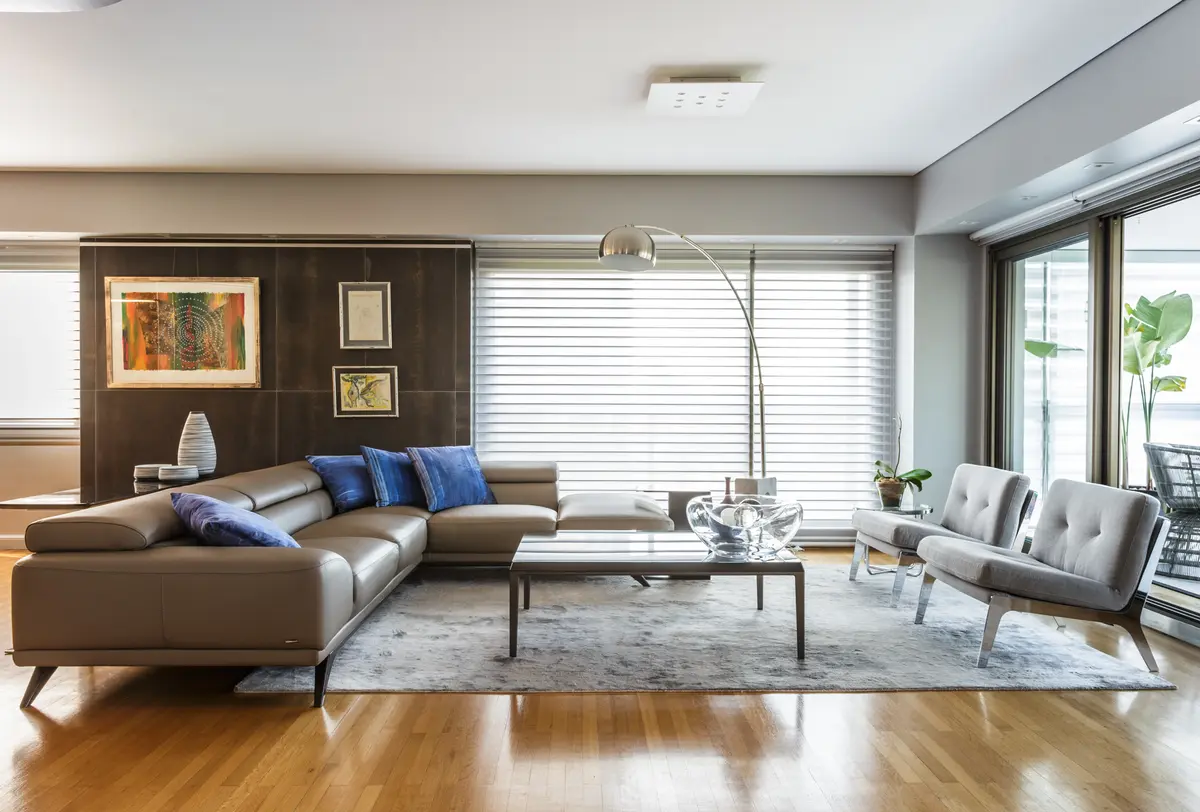 Sala de estar moderna com sofá modular cinza e janelas amplas — projeto Piso en Belgrano, por Gutman+Lehrer Arquitectas, em Belgrano