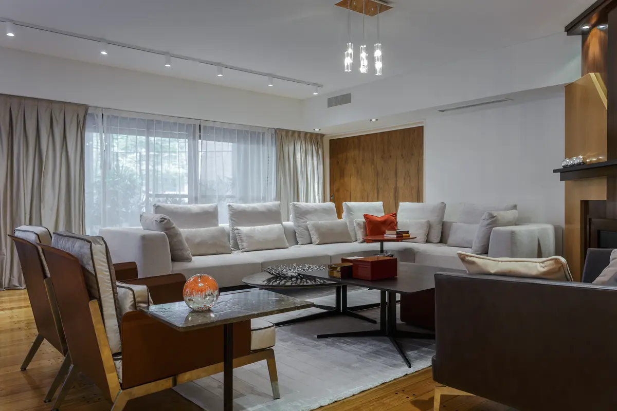 Sala moderna com janelas do chão ao teto e sofá modular — projeto Piso en Belgrano III, por Gutman+Lehrer Arquitectas, em Belgrano
