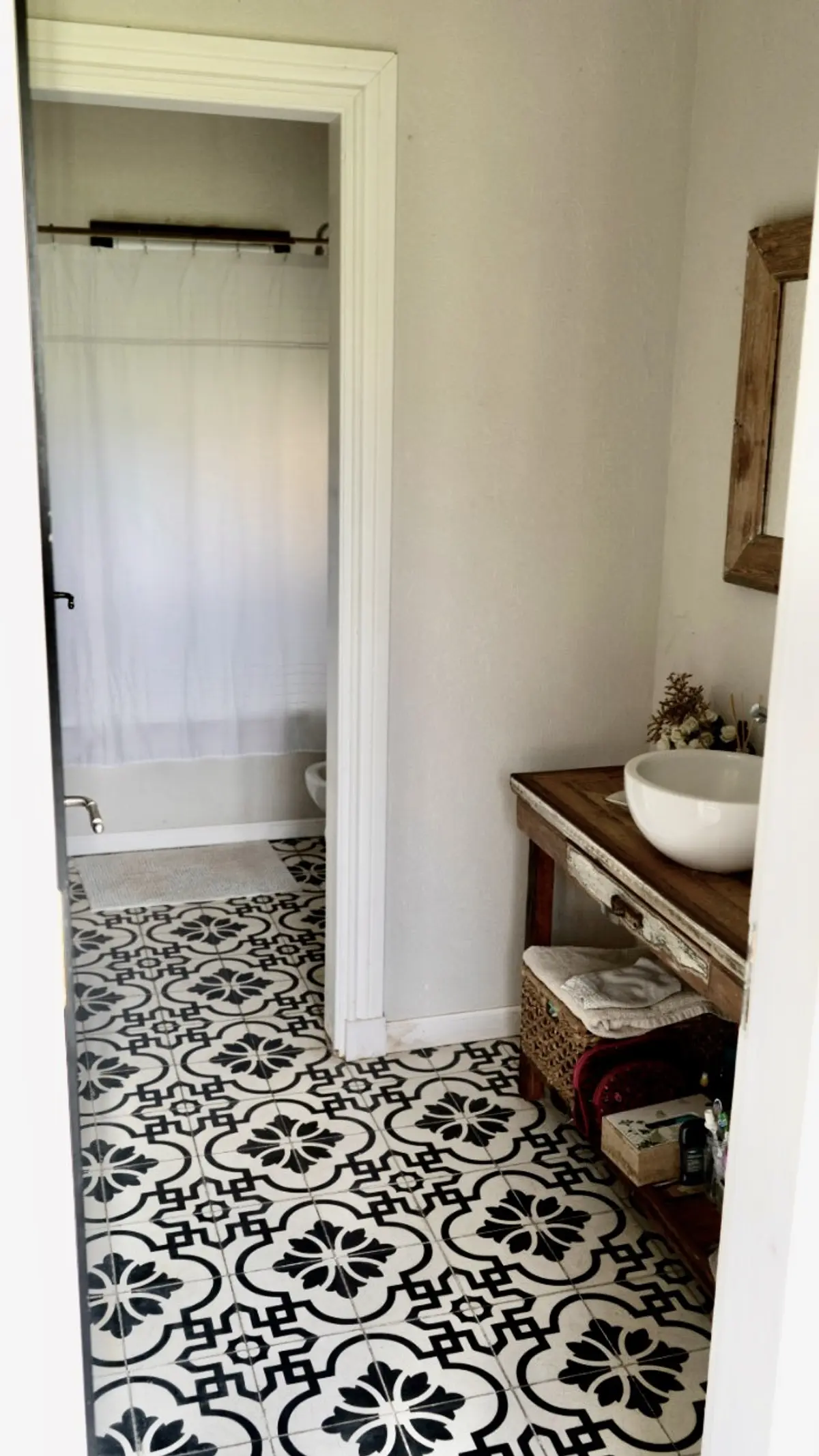 Baño con piso de patrón geométrico y vanitory de madera rústica — proyecto Los Jazmines Pilar del Este, por Marconi Silva Arquitectos, en Pilar del Este