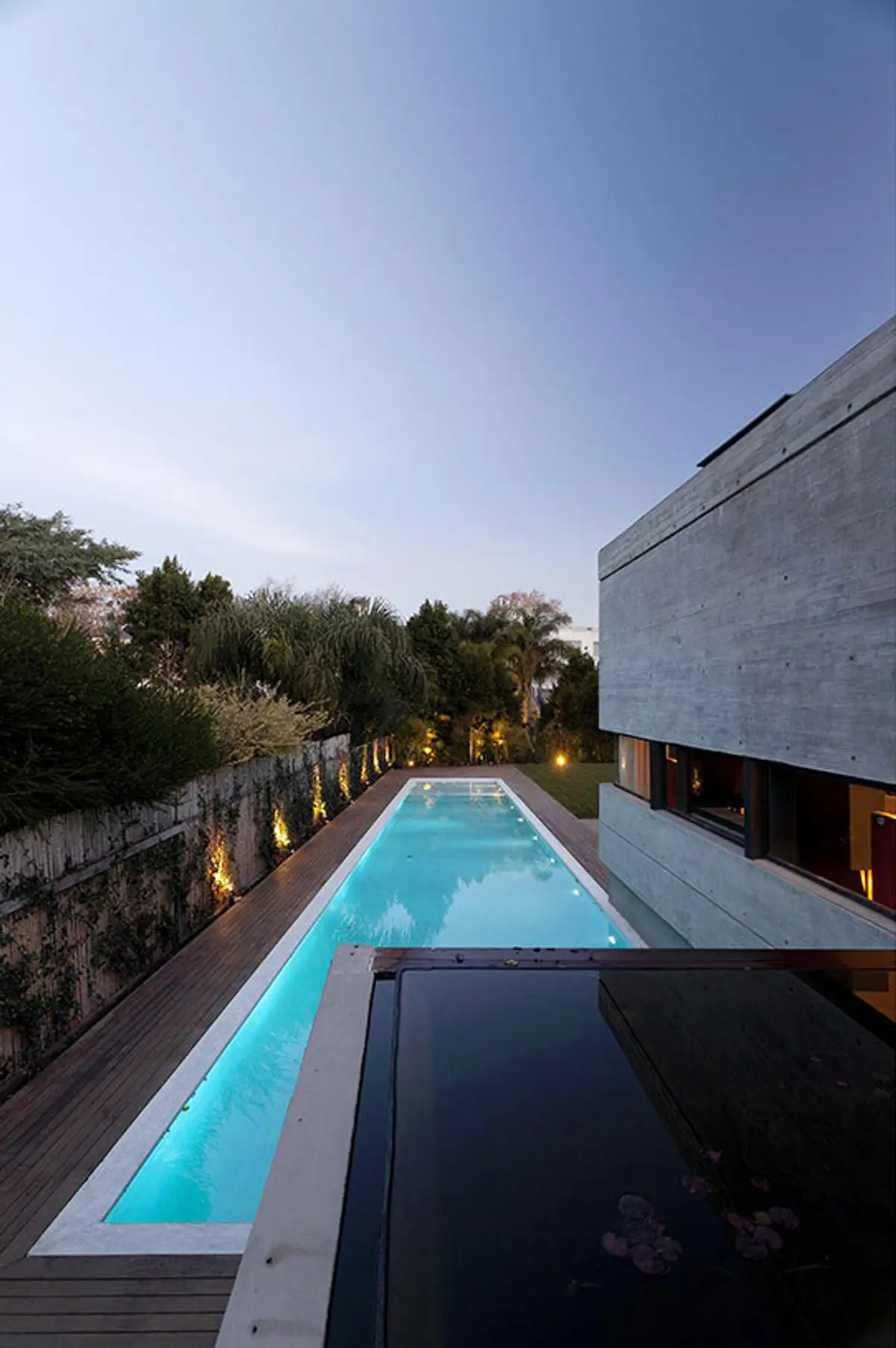 piscina de borde infinito en casa moderna con detalles brutalistas — proyecto Acasusso, por Remy Arquitectos, en Acassuso