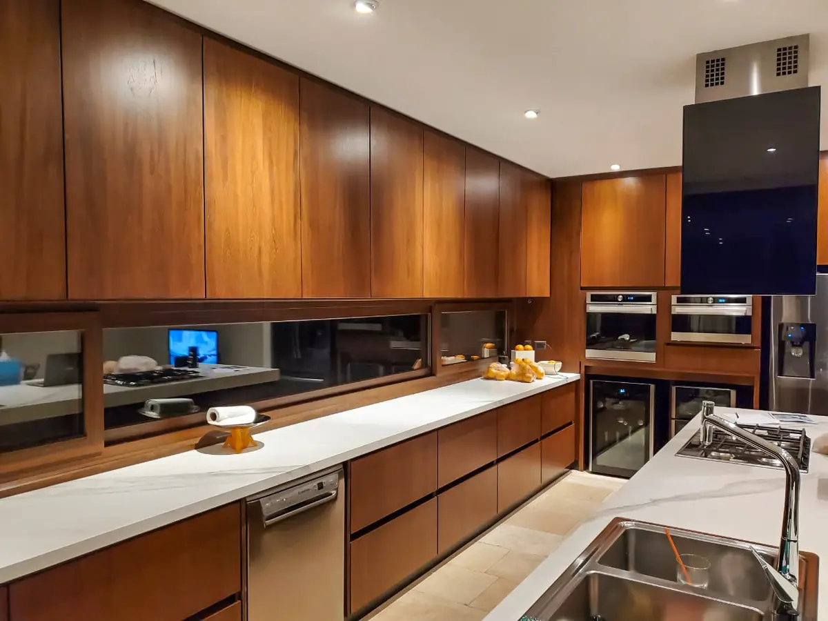 Cozinha moderna com armários de madeira integrados e bancadas de mármore branco — projeto EL GOLF, NORDELTA, por Greschek Obras, em Nordelta