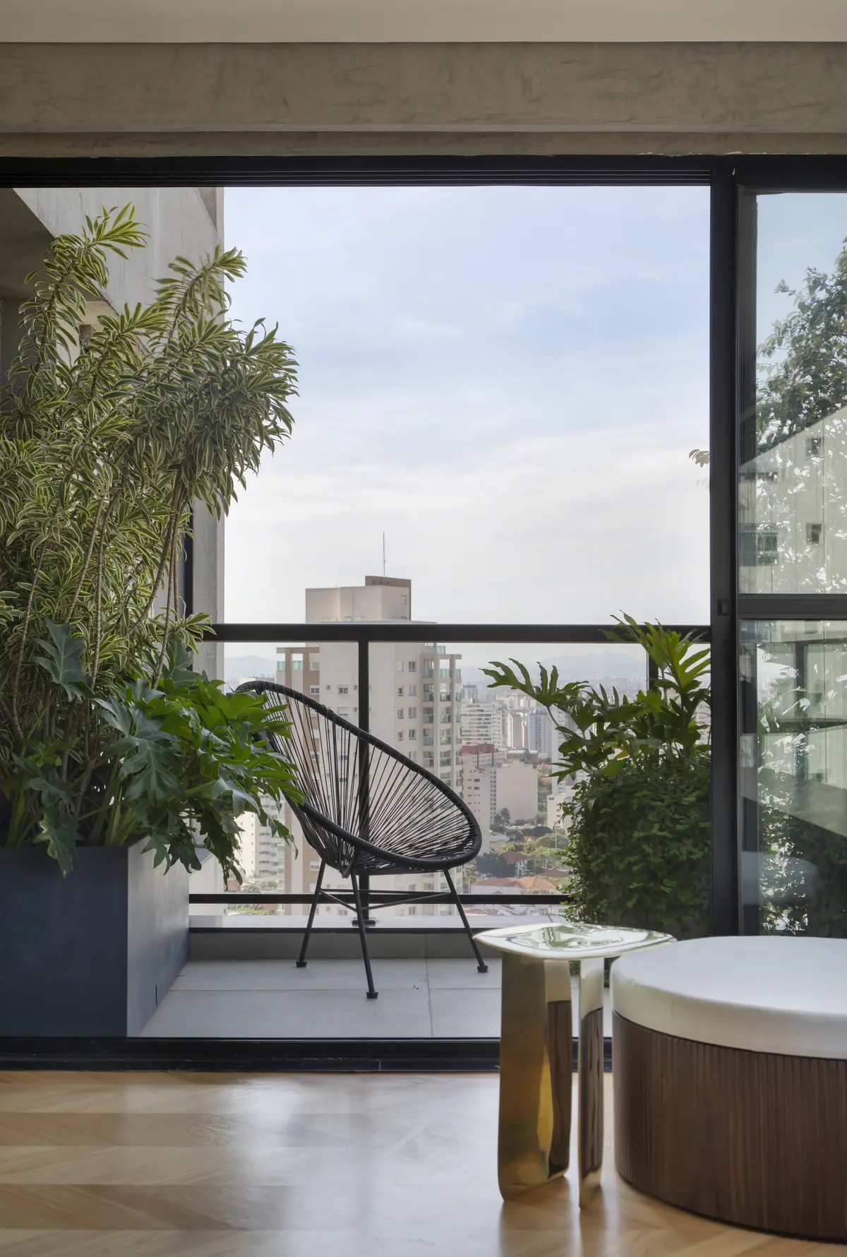 Terraza moderna con silla de mimbre y vistas a la ciudad — proyecto BP Hose , por Studio Ro-ca