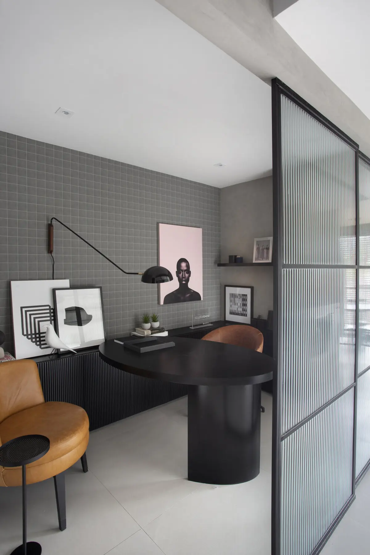 Oficina contemporánea con escritorio negro, silla de cuero y tabique vidriado — proyecto Decorado Latitud, por Studio Ro-ca