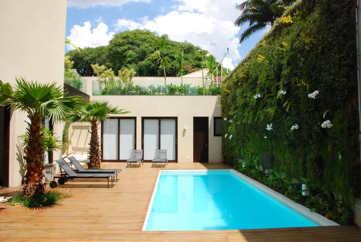 Patio moderno con pileta azul, deck de madera y jardin vertical — proyecto Residência EC, por Gil Fialho