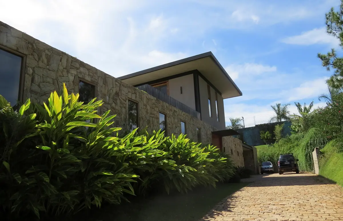 Casa contemporánea piedra con jardín y acceso de grava — proyecto Residencia PZ, por Gil Fialho