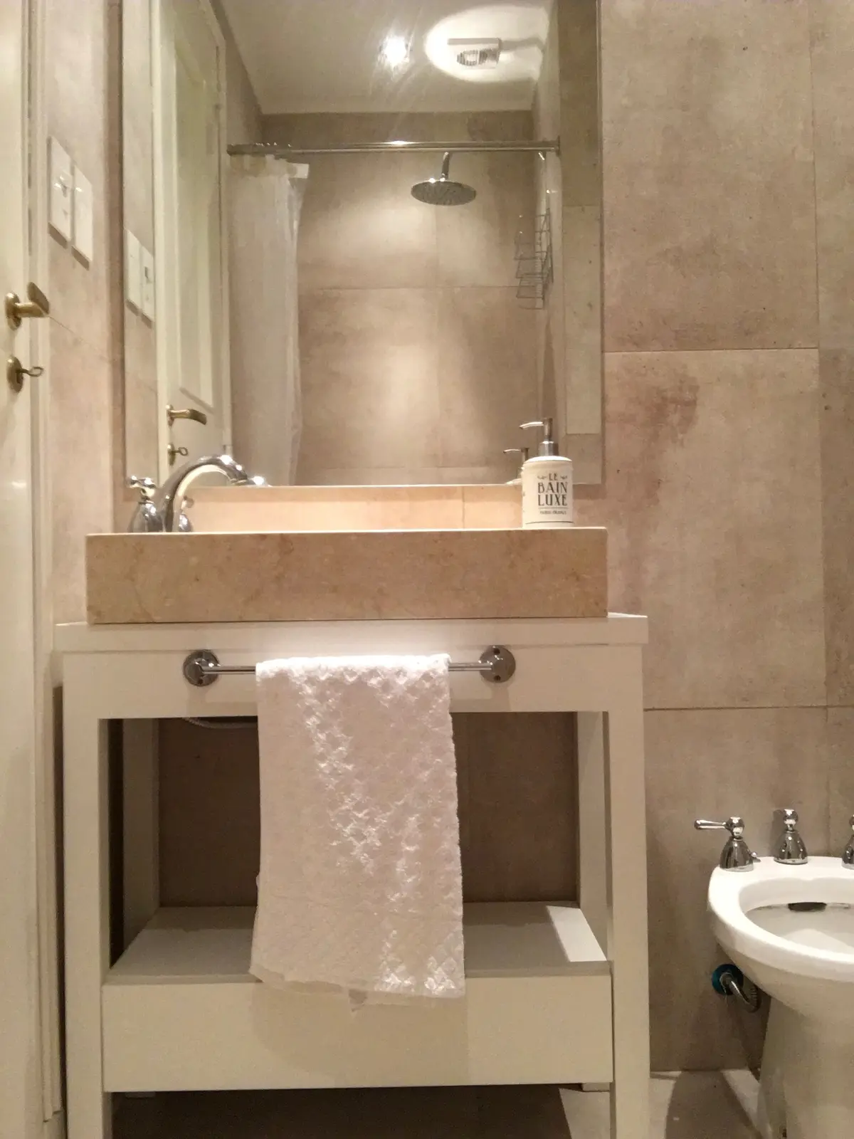 Bano moderno con mesada marmol, espejo grande y ducha vidrio — proyecto Salguero, por Rioja Arquitectura, en Palermo