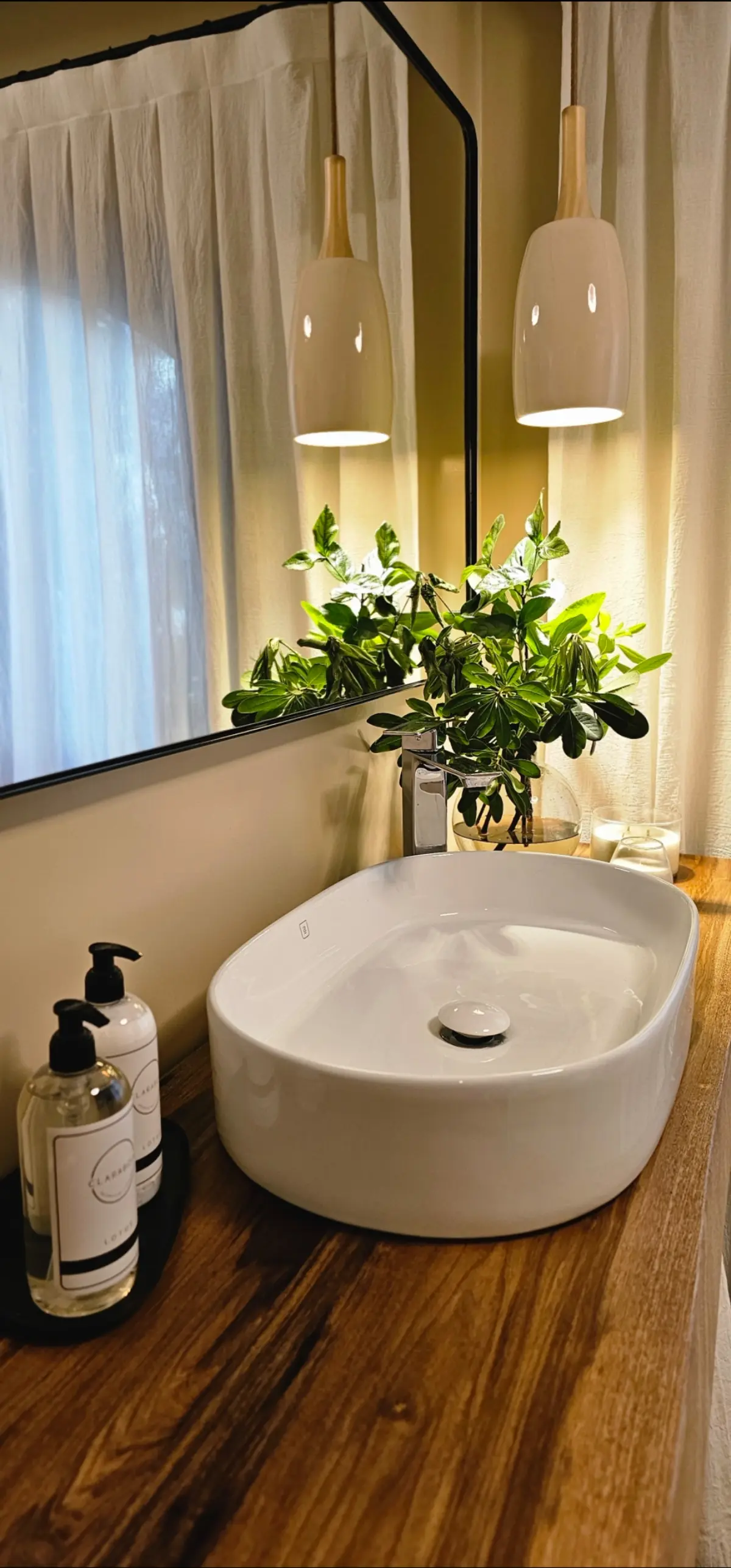 Baño moderno con lavabo sobre encimera de madera y luces colgantes — proyecto Fatima , por Claraboia , en Pilar