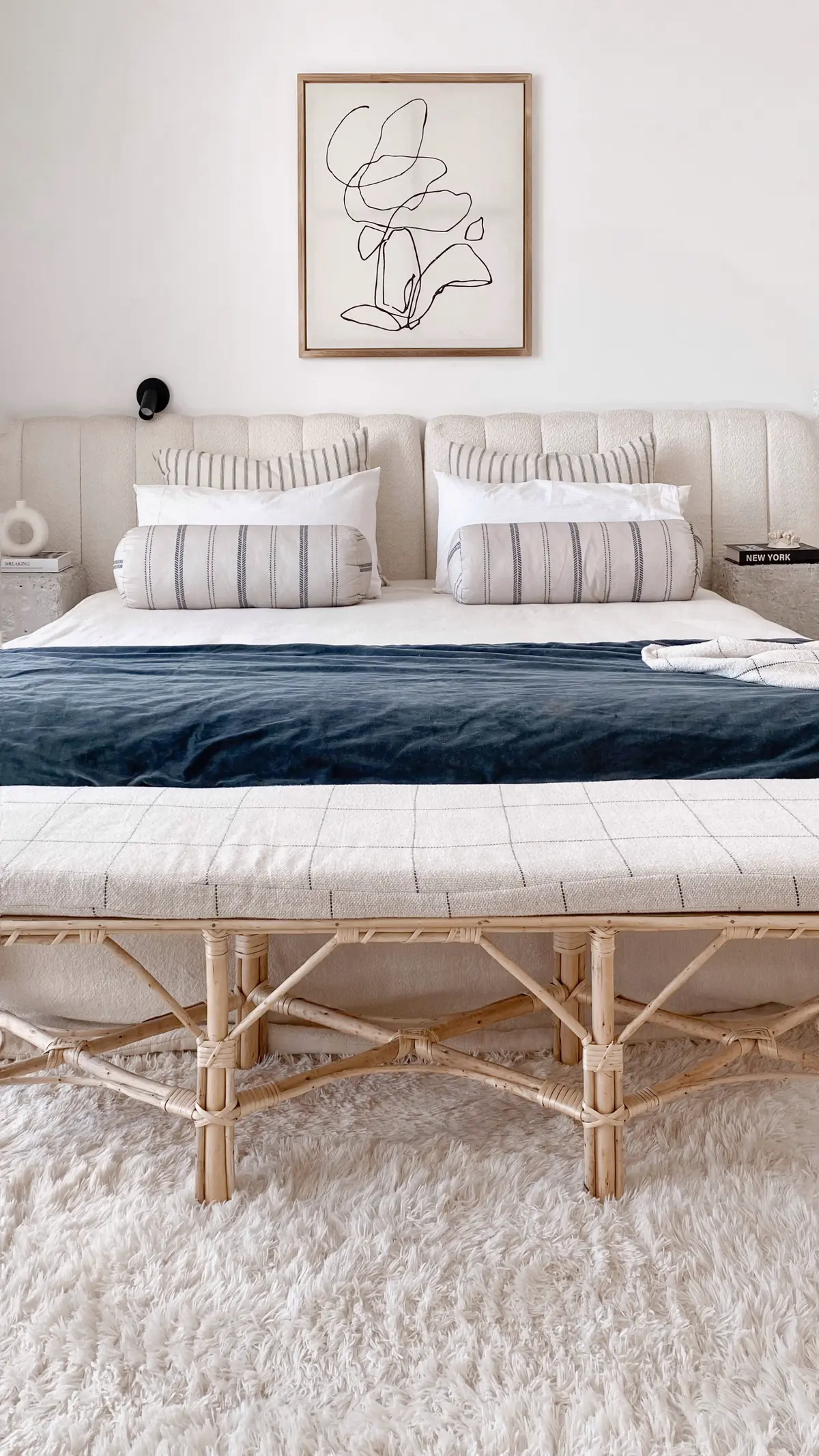 Dormitorio boho escandinavo con banco de ratán y arte abstracto — proyecto El Refugio, por Grupo Pauta Arquitectura, en Pinamar