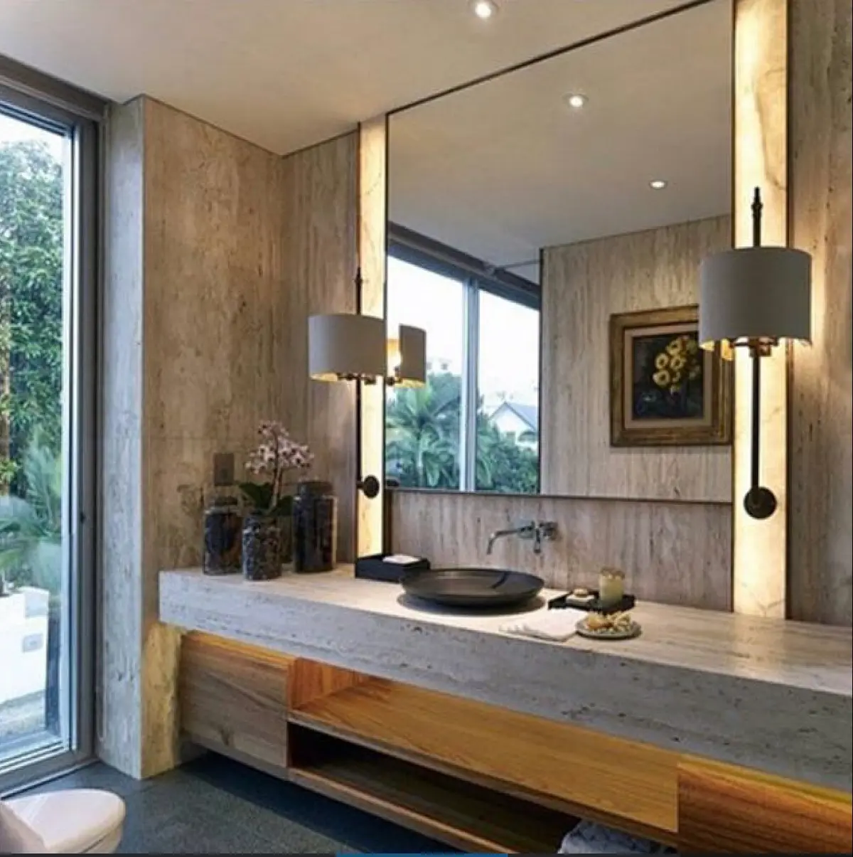 baño moderno con paredes de piedra, espejo grande y mueble de madera — proyecto BALCARCE MTZ, por Estudio G, en Martínez