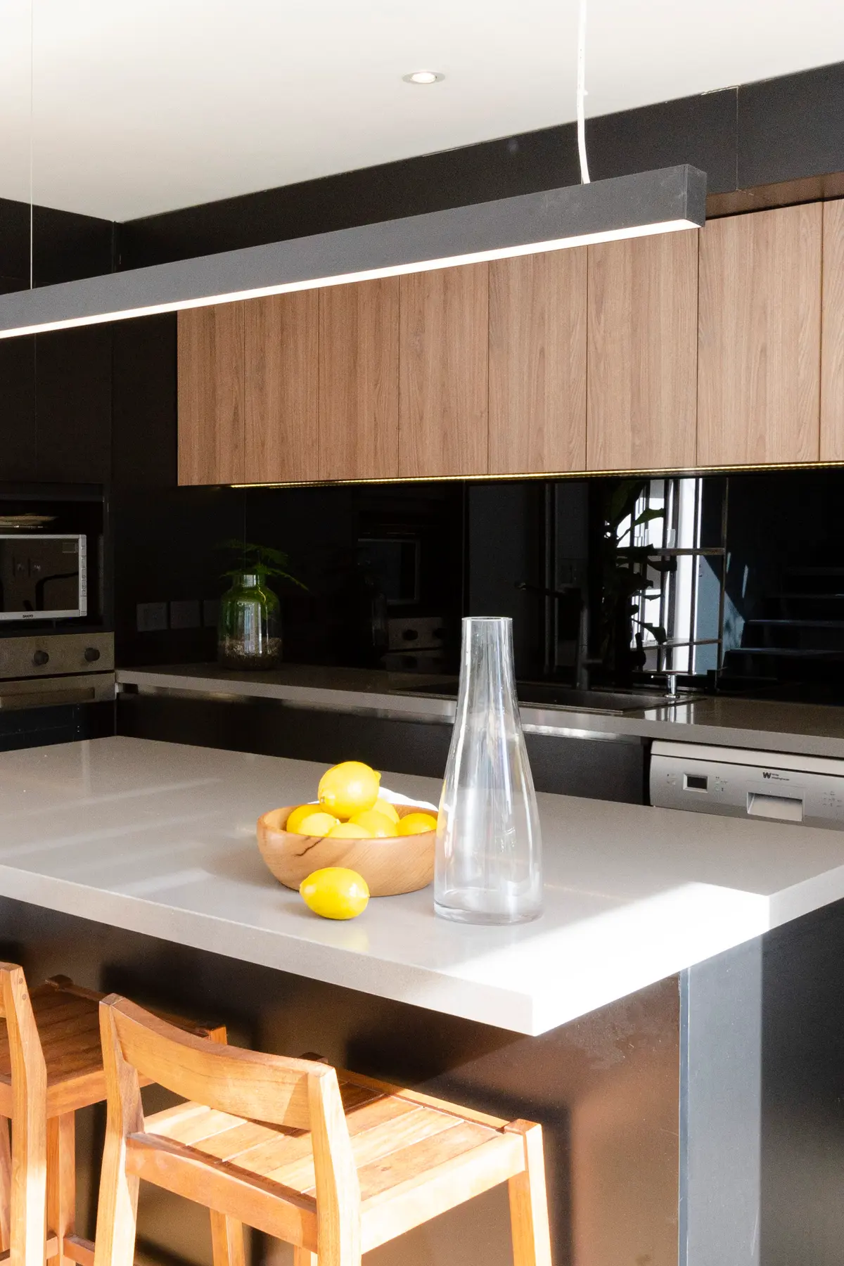Cocina moderna con isla y gabinetes de madera, luz lineal — proyecto Guayra - Andrea Gonzales, por ABEJA CONCEPT, en Belgrano