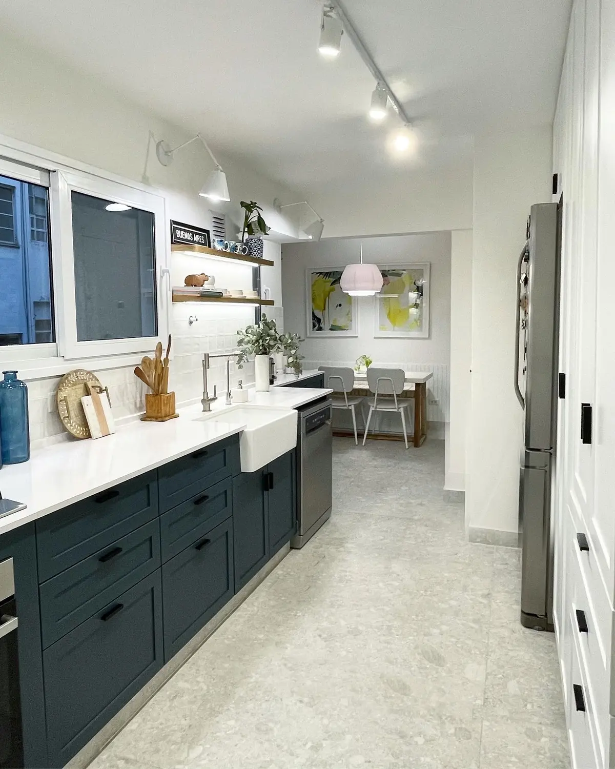 Cocina moderna con muebles azul oscuro, mesada de mármol y bacha de campo — proyecto Paraná, por JT ARQUITECTURA, en Buenos Aires
