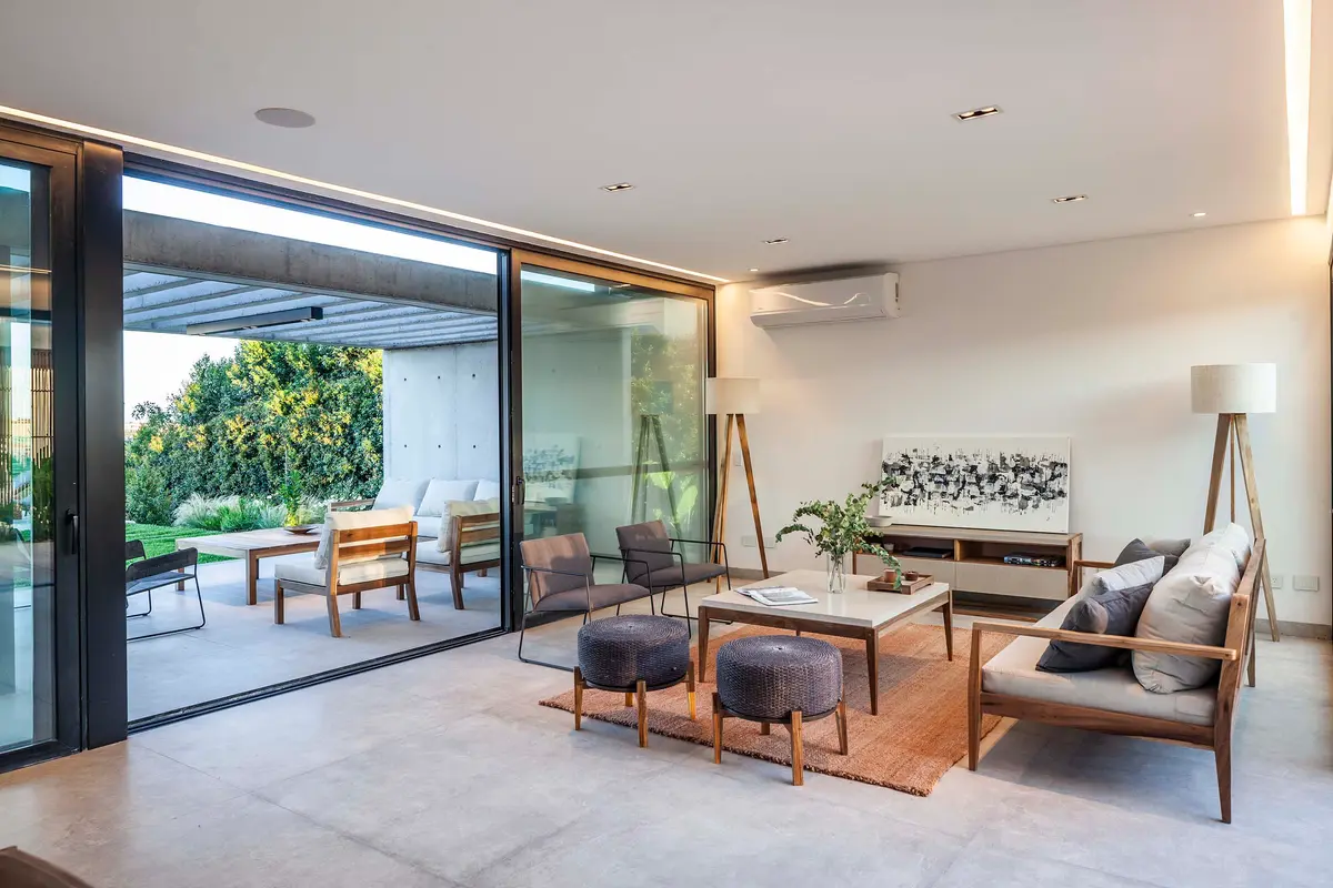 Sala moderna com janelas amplas e luz natural — projeto CASA J2M, por GMARQ, em Belén de Escobar