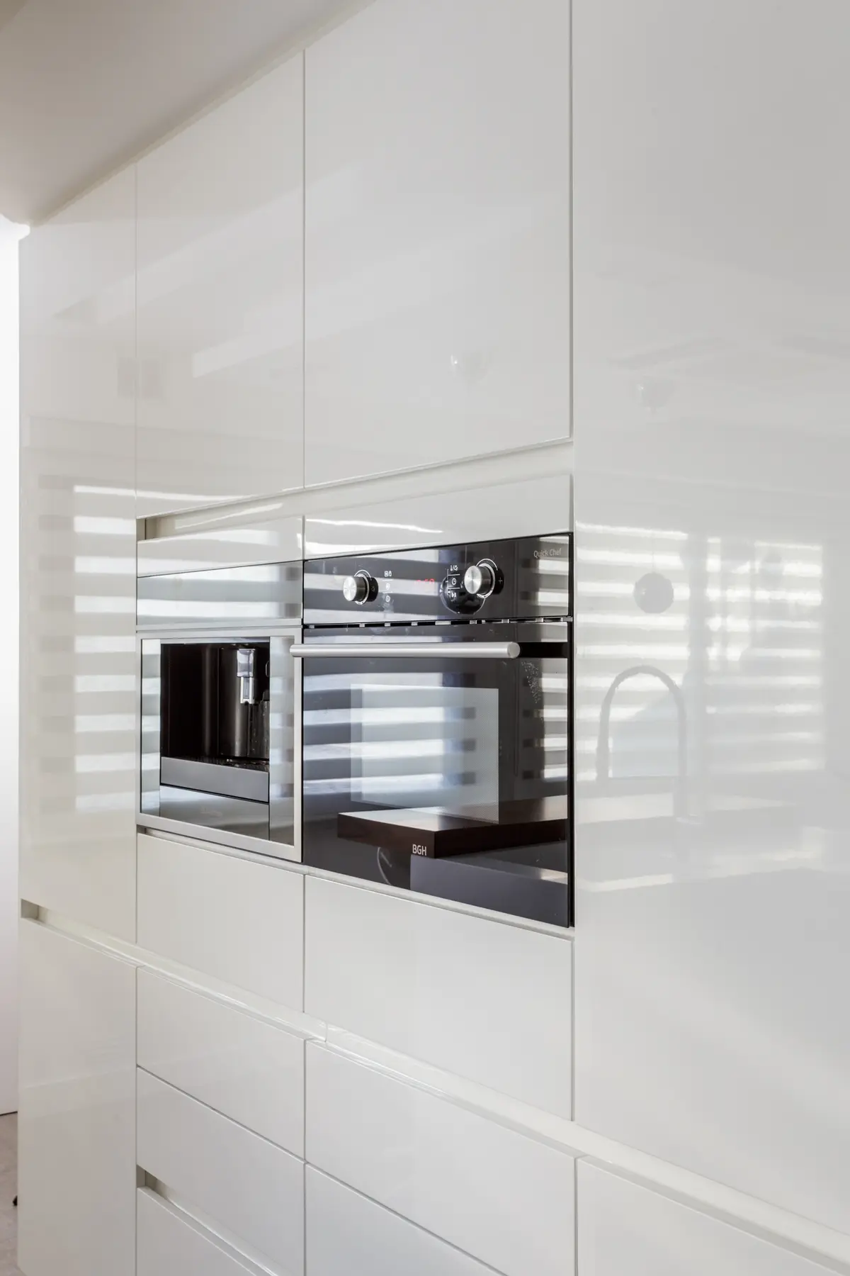 Cocina moderna blanca y minimalista con electrodomésticos integrados — proyecto Piso en Belgrano, por Gutman+Lehrer Arquitectas, en Belgrano