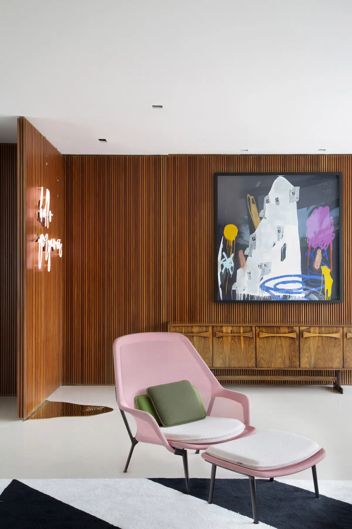 Living con sillón rosa, madera vertical y arte contemporáneo — proyecto BM House, por Studio Ro-ca