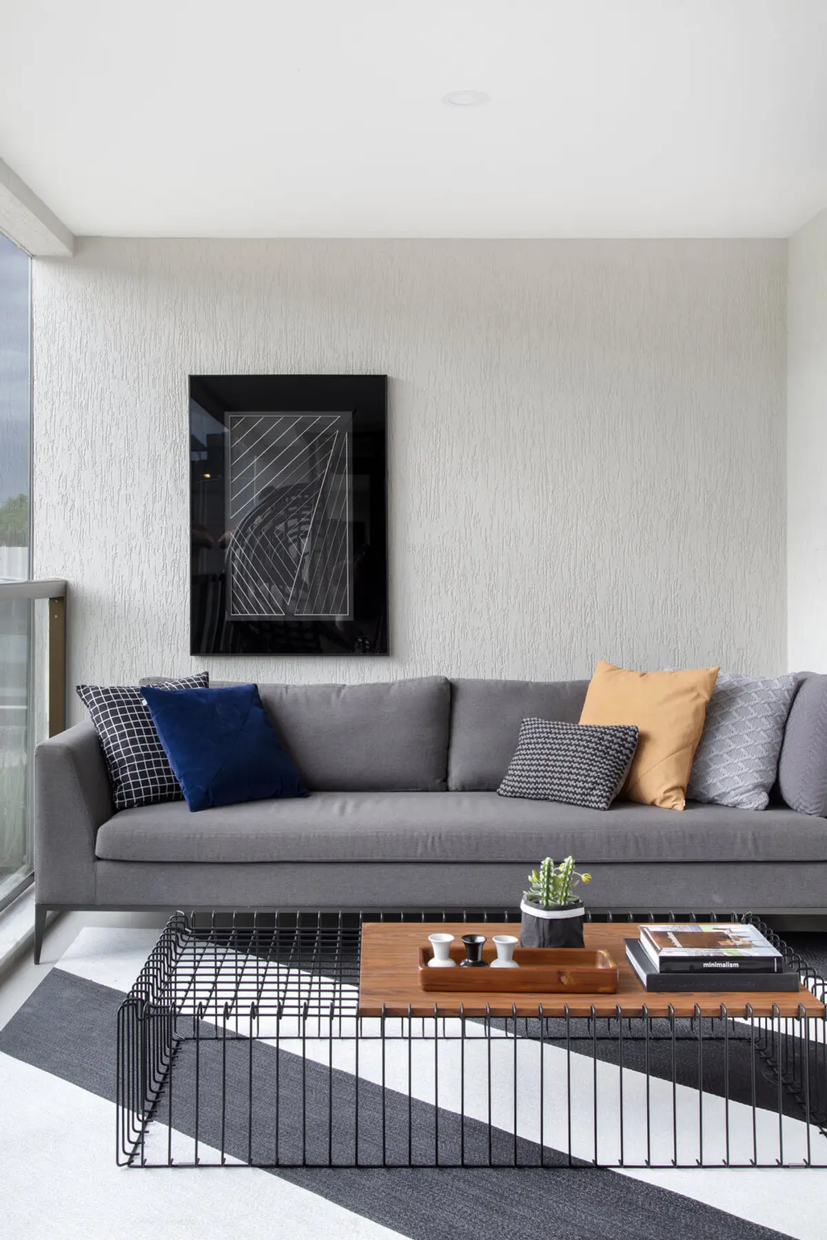 Living moderno con sofá gris, mesa de madera y cuadro negro — proyecto Decorado Latitud, por Studio Ro-ca