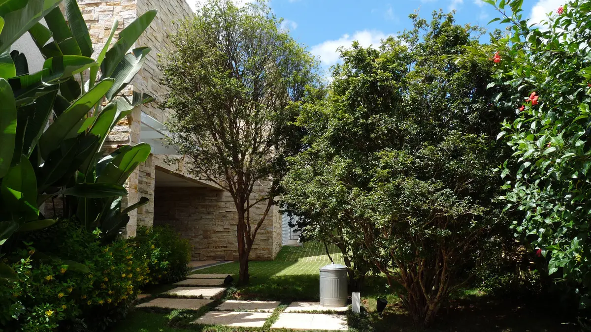 Patio con jardin y acceso a vivienda contemporanea en piedra — proyecto Residência NK, por Gil Fialho