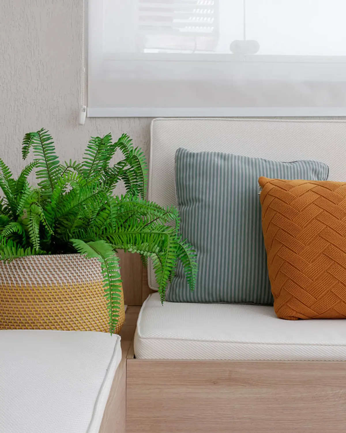 Living con sofá beige, almohadones gris y terracota, planta en maceta mimbre — proyecto Apartamento Santa Rosa, por Amanda Miranda