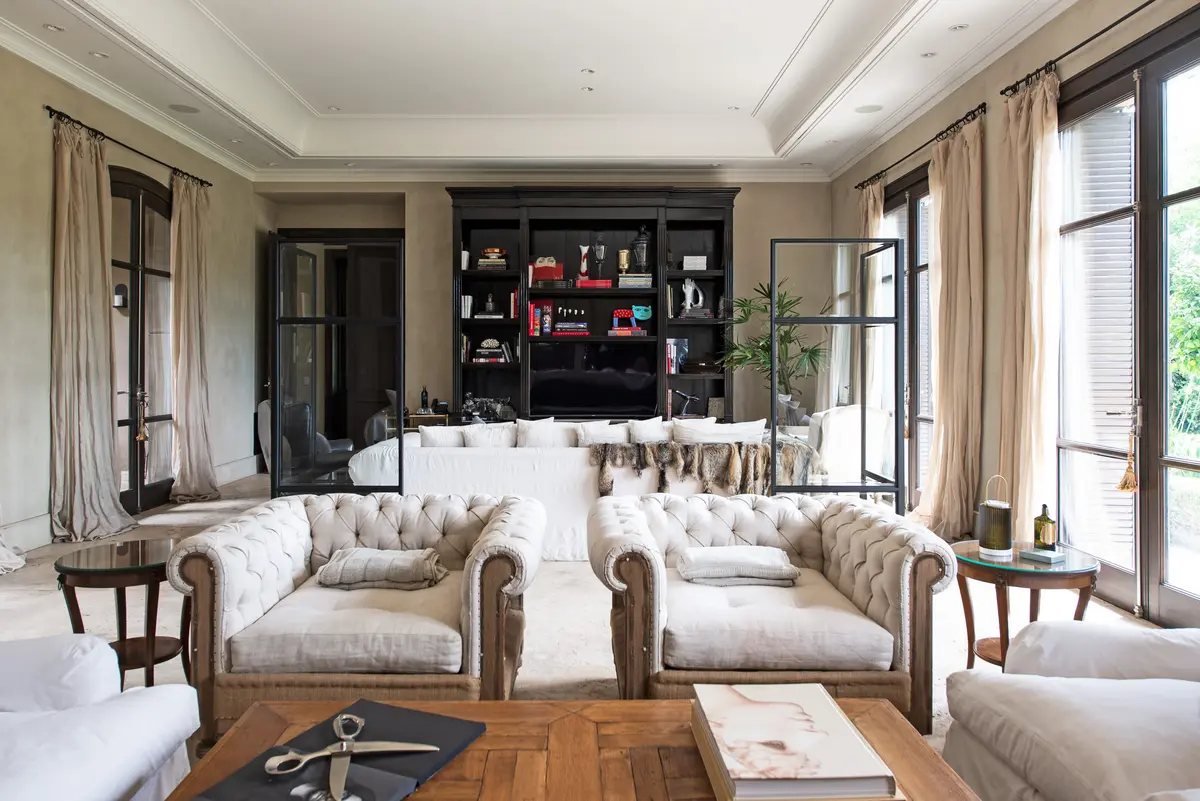 Living clasico con sofas chester blancos y biblioteca empotrada — proyecto Casa Toscana , por Estudio Du 