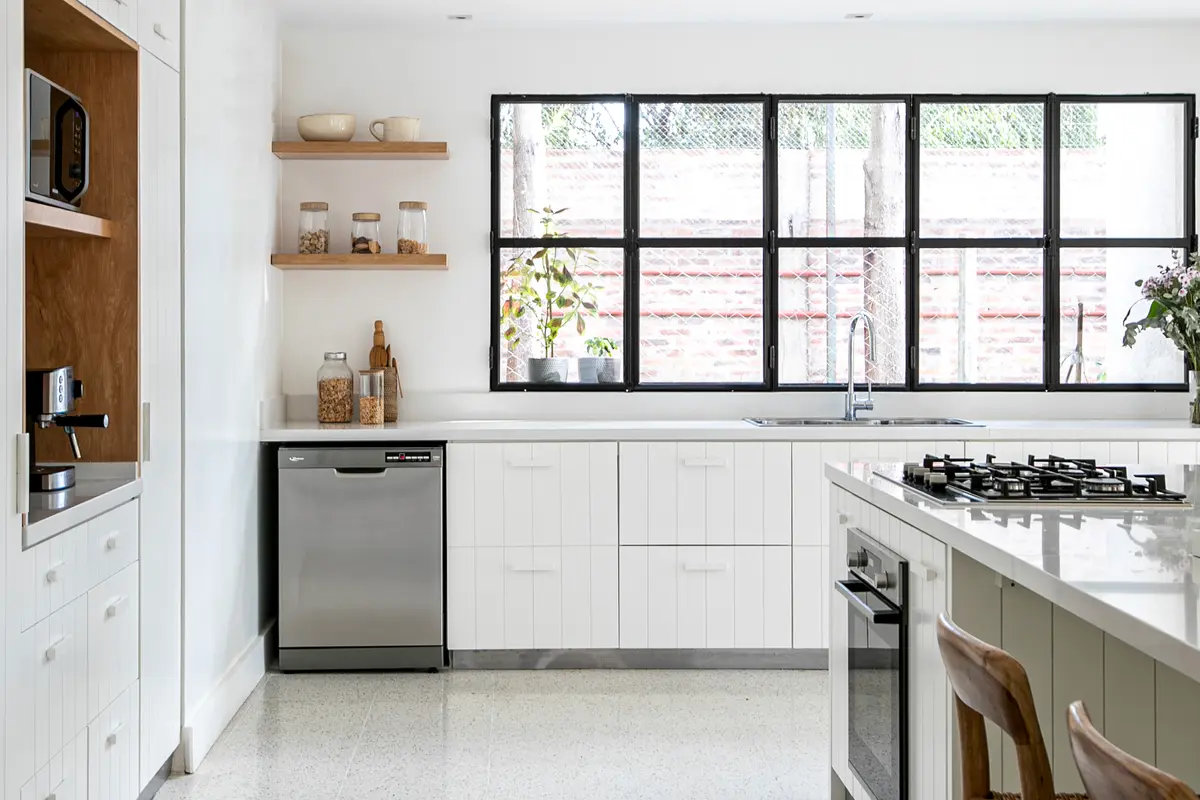 Cozinha escandinava moderna com armários brancos e janela grande — projeto Laguna del Sol, por Parq Estudio, em Tigre