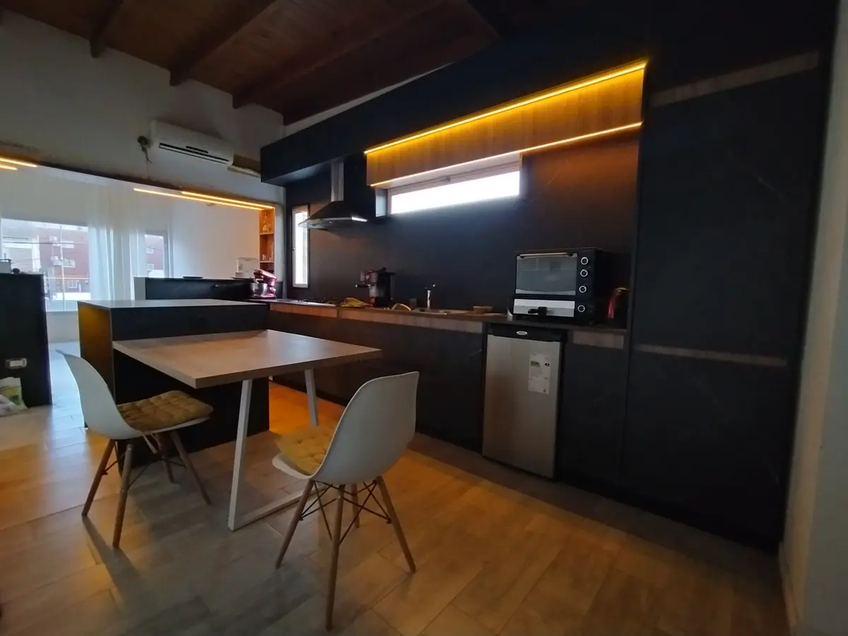 Cozinha moderna com bancada e sala de jantar integrada, acabamentos pretos — projeto Diseño personalizado a gusto del cliente, por Saavedra Amoblamientos, em Pinamar