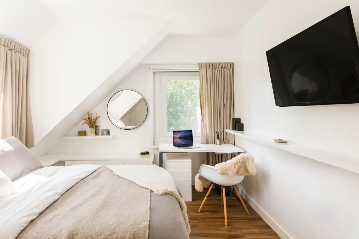 Dormitorio escandinavo con escritorio integrado bajo techo inclinado — proyecto Boating Club, por SRMD Arquitectura, en Boating Club