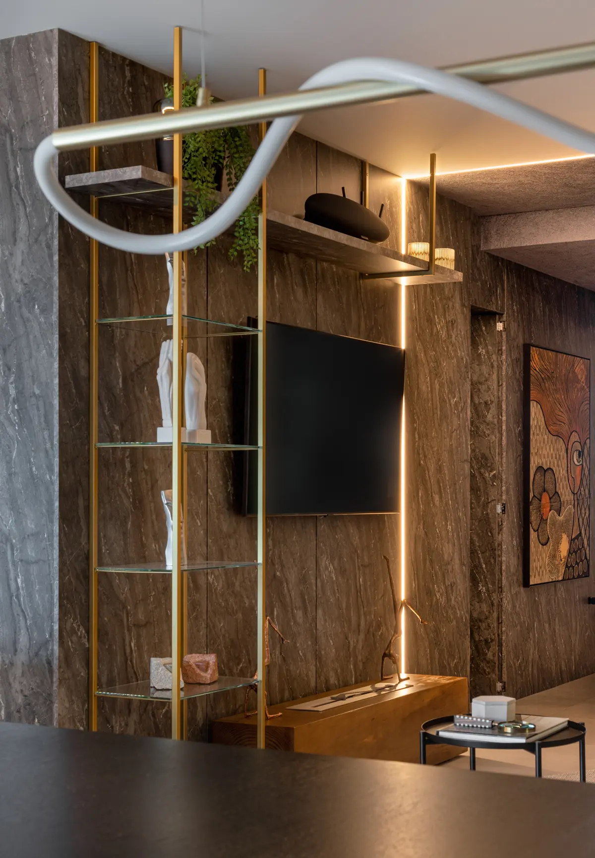 Sala de estar moderna com estante dourada e iluminação indireta — projeto Argos Black - Living, por Geovani Capelina Arquitetura