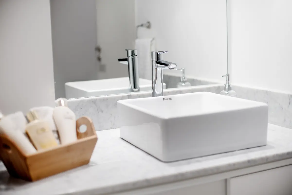 Baño moderno con lavabo sobre encimera y detalles en mármol — proyecto República de la India, por Estudio Basa, en Palermo