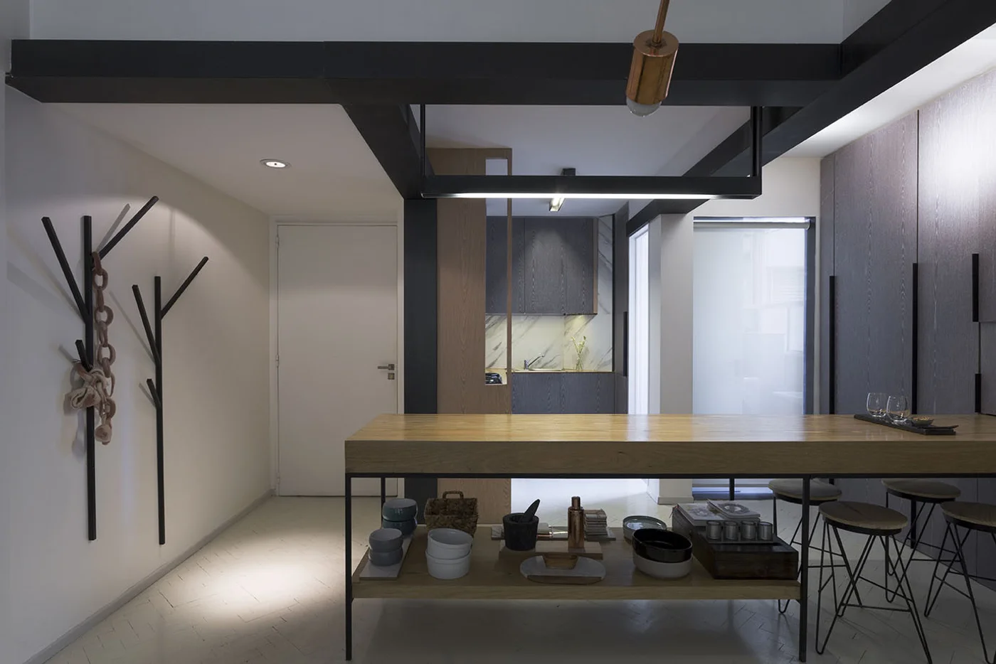 Cocina moderna industrial con isla de madera y perchero de ramas.