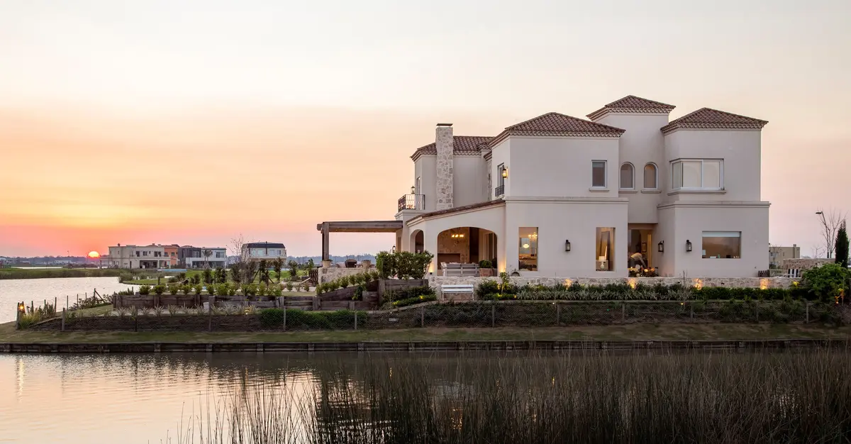 Casa mediterrânea à beira d'água ao pôr do sol — projeto Casa MF, por Estudio Junor, em Belén de Escobar