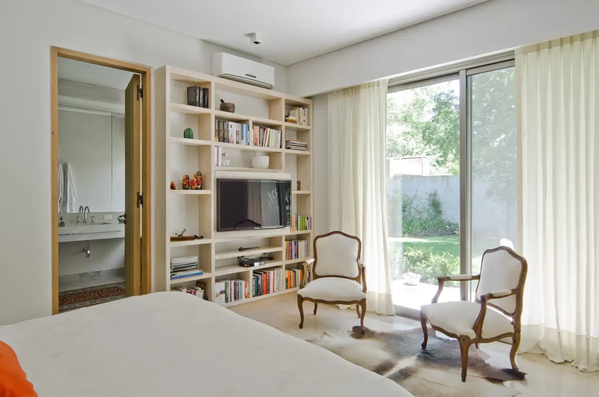 Sala de estar com estante moderna e poltronas clássicas — projeto Casa P, por Estudio Dado, em San Isidro