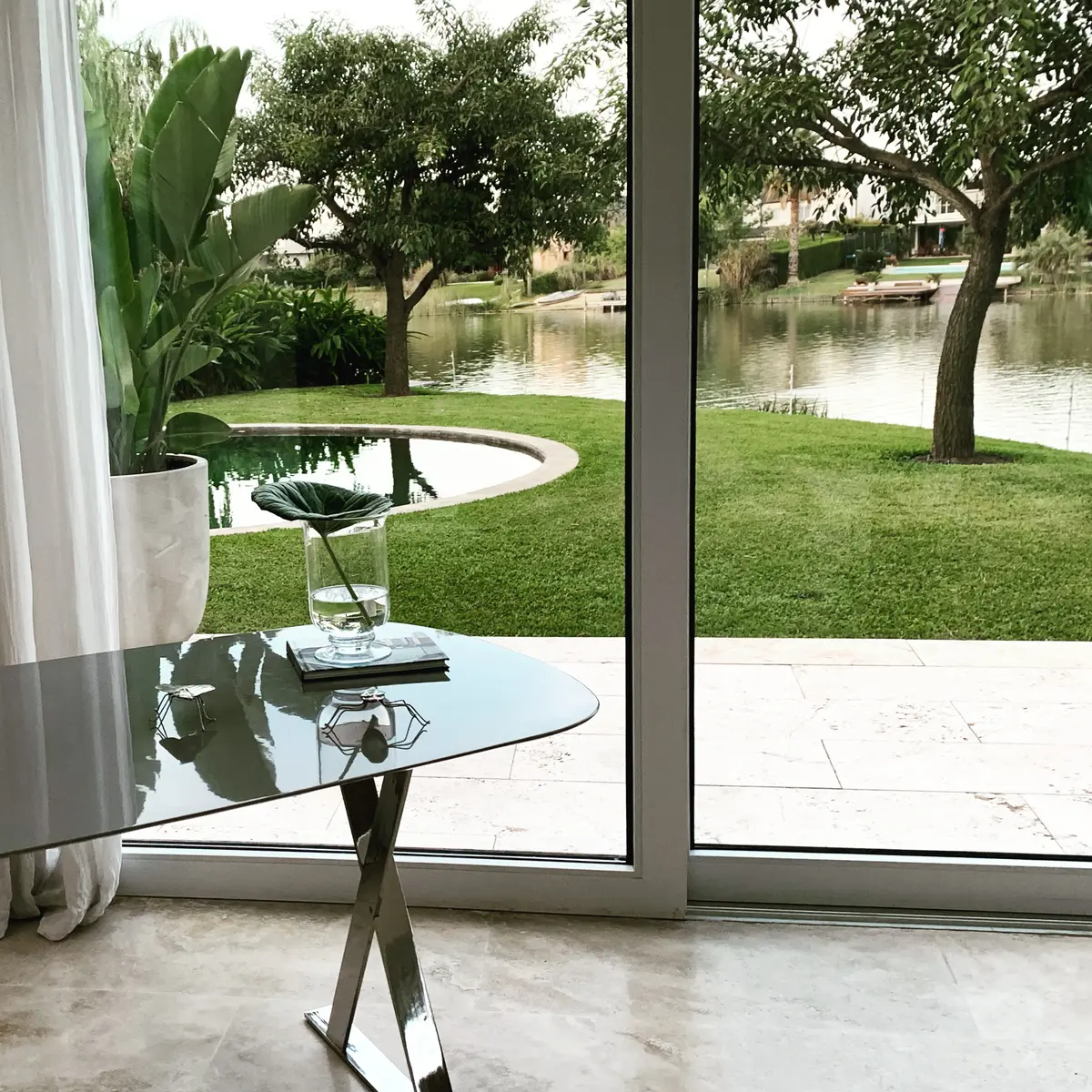 Terraço moderno com vista para água e vegetação exuberante — projeto CASA LAGUNA, por Estudio Xime Fontan Balestra, em Tigre