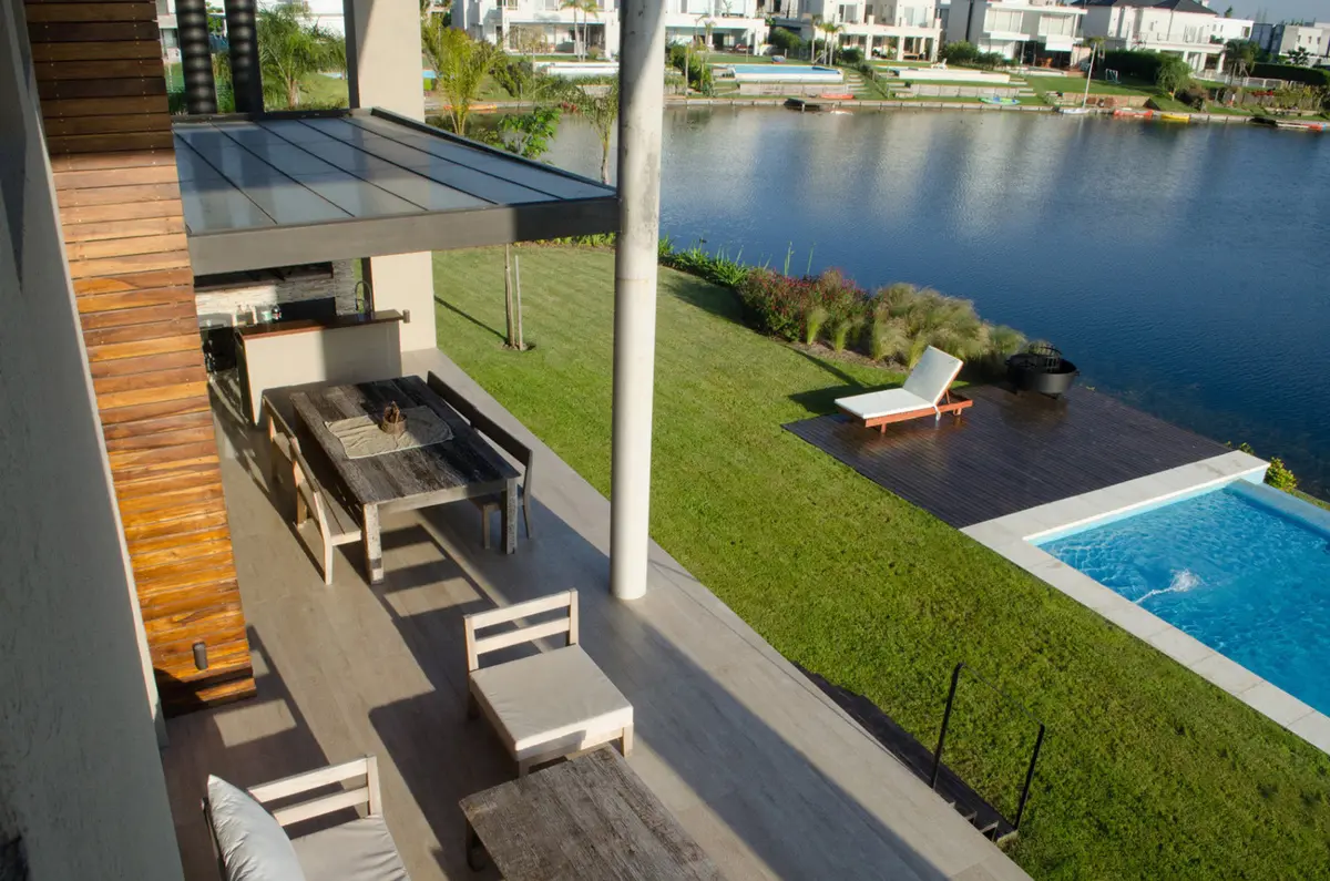 Varanda moderna com piscina e vista para o lago — projeto Casa Nordelta, por linearecta.arquitectura, em Nordelta