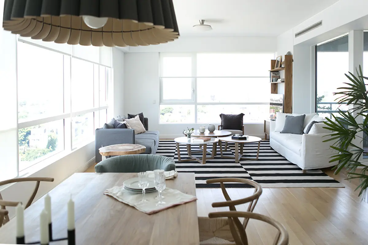 Living comedor moderno con grandes ventanales y lámpara colgante de madera — proyecto BA 1 2016, por Mesopotamia Ba, en CABA