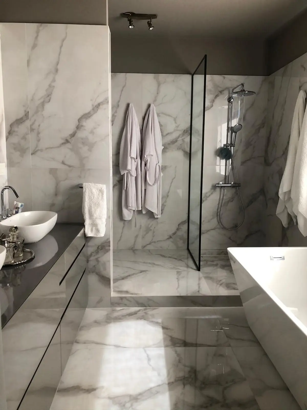 Banheiro moderno com mármore, banheira de chão e chuveiro de vidro — projeto Casa Nordelta, por Etude Interiorismo, em Nordelta