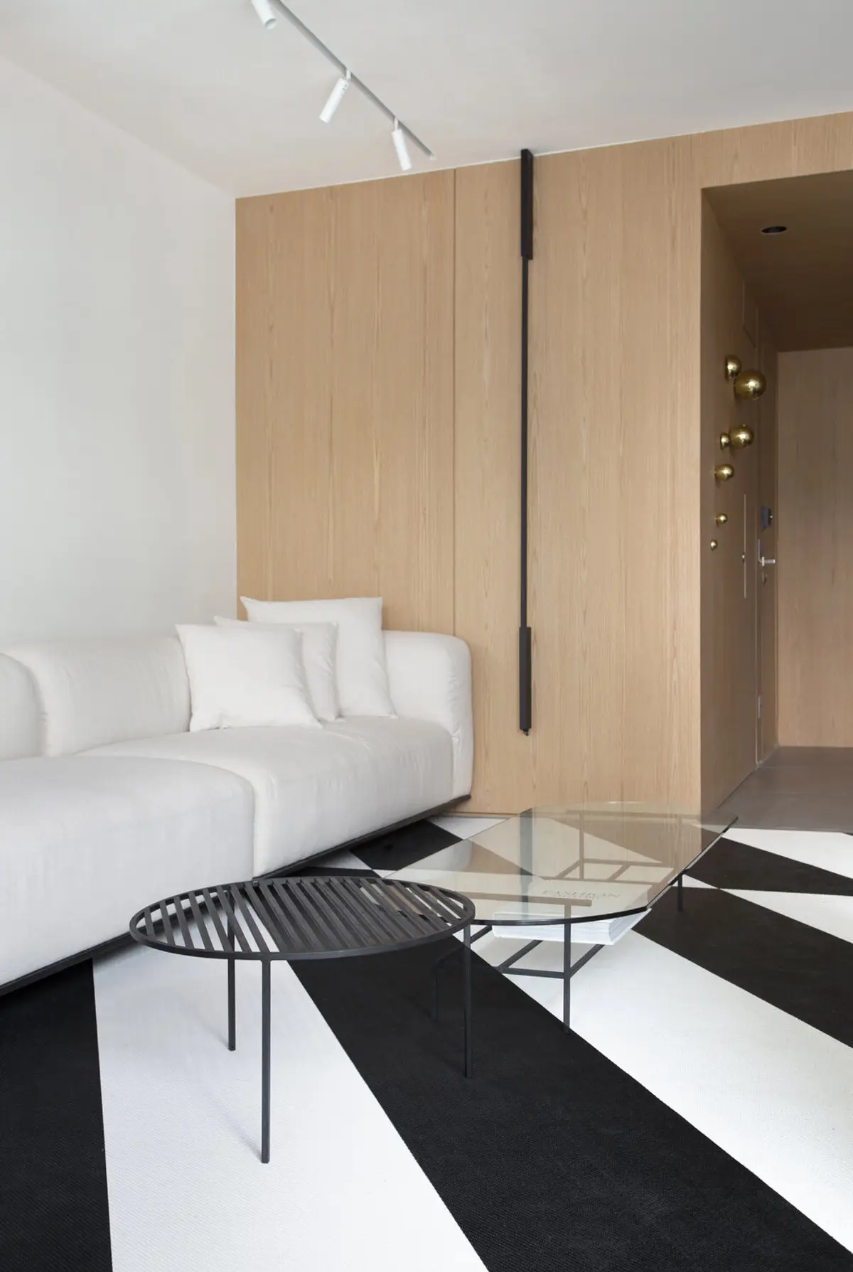 Dormitorio minimalista con panel madera, sofá blanco y piso geométrico — proyecto MN House, por Studio Ro-ca
